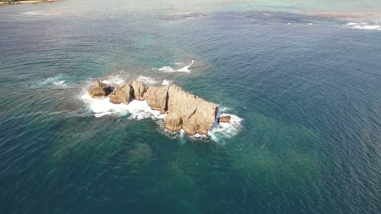 海に浮かぶ岩礁のドローン空撮